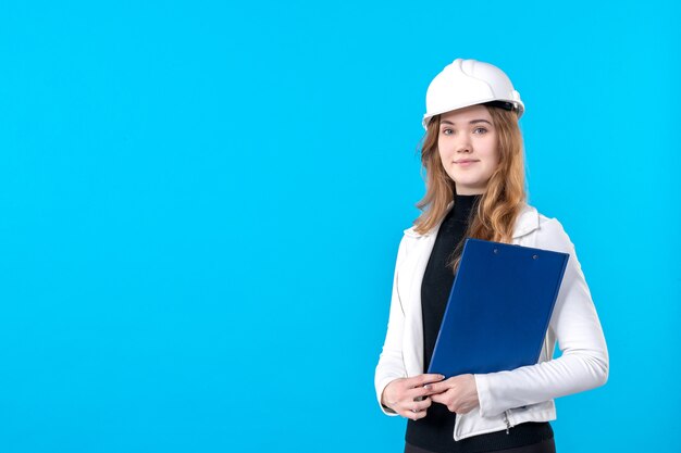 Free photo front view female architect holding blue file plan on blue