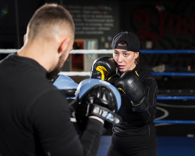 Free Photo front view of female boxer training while wearing protective gloves