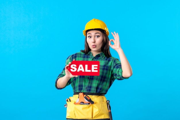 Front view female builder holding red sale writing on blue