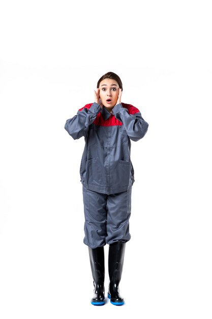 front view of female builder in special uniform on white wall