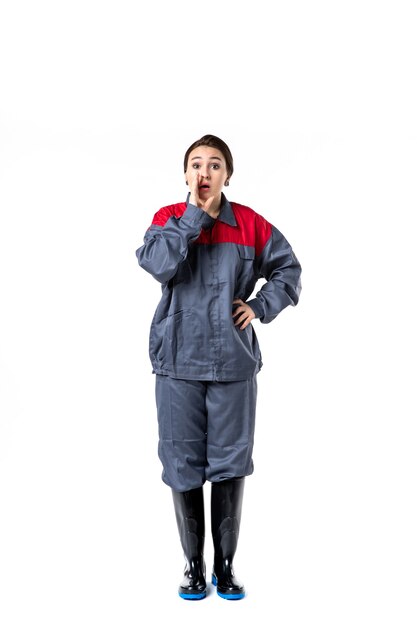 front view of female builder in special uniform on white wall