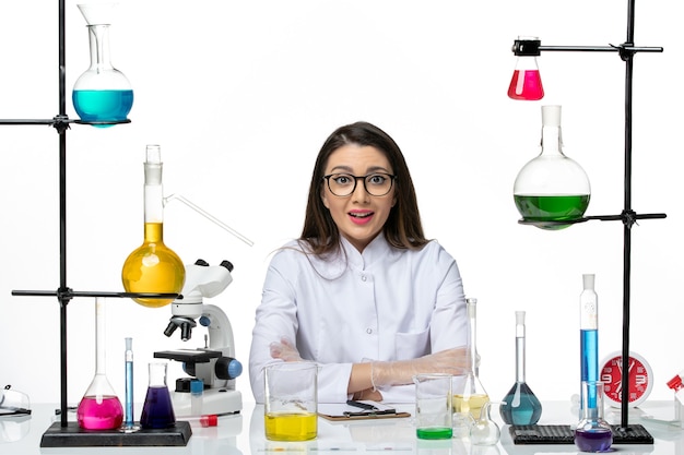 Free photo front view female chemist in white medical suit just sitting with solutions on light white background science virus covid- pandemic lab