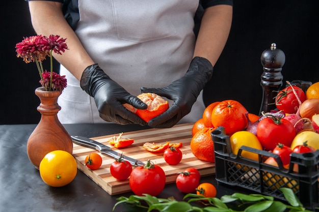 Front view female cook cleaning tangerines on dark cooking salad health diet vegetable meal food fruit job