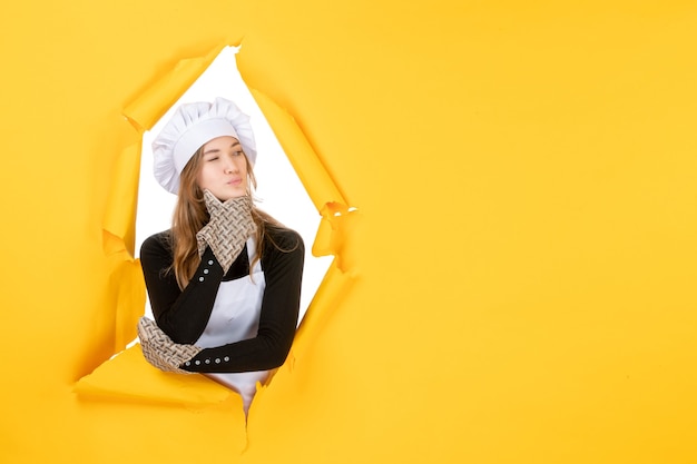 Free Photo front view female cook in cook gloves and white cook cap on yellow food color cuisine photo emotion kitchen job