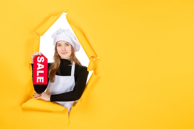 Front view female cook holding red sale writing on yellow money job photo kitchen cuisine emotion food