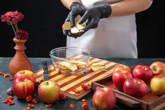 Free photo front view female cook putting apples into plate on dark fruit juice diet salad food meal exotic work pie cake