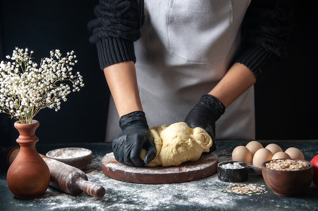 Free photo front view female cook rolling out dough on dark pastry job raw dough hotcake bakery pies oven