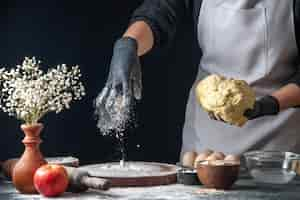 Free photo front view female cook rolling out dough with flour on dark job dough pastry kitchen hotcake cuisine bakery egg