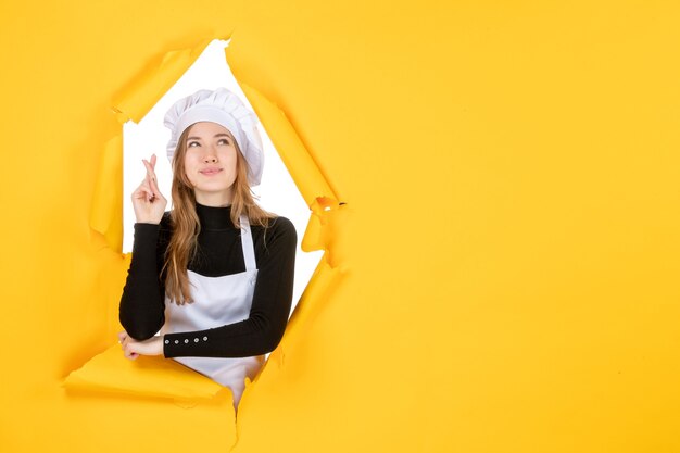 Front view female cook on yellow sun color paper food job photo cuisine emotions