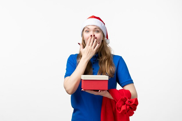 Front view of female courier excited with present on white wall