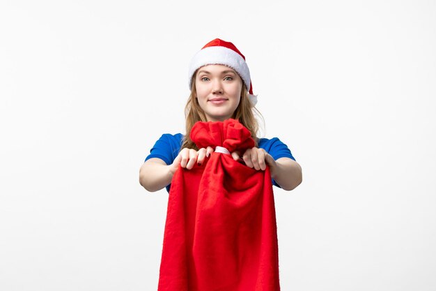 Front view of female courier holding present bag on the white wall