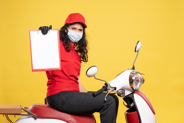 Free Photo front view female courier in mask holding file note on yellow background covid- job uniform worker service pandemic delivery