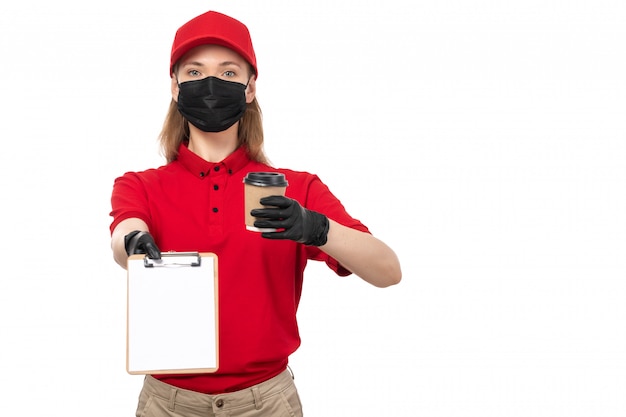 A front view female courier in red shirt red cap black gloves holding coffee on white