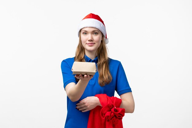 Front view of female courier with food delivery on a white wall