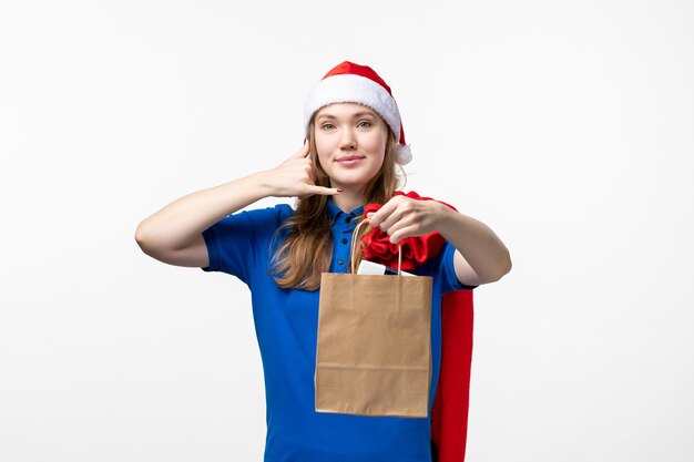 Front view of female courier with holiday present on a white wall