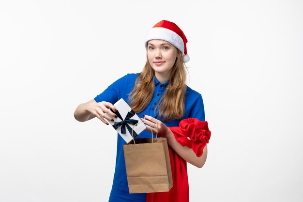 Front view of female courier with holiday present on white wall