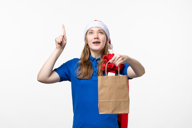 Front view of female courier with holiday present on white wall