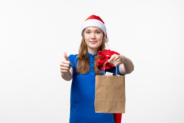 Front view of female courier with holiday present on white wall