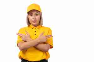 Free photo a front view female courier in yellow cap yellow shirt and black jeans posing on white background delivery girl service