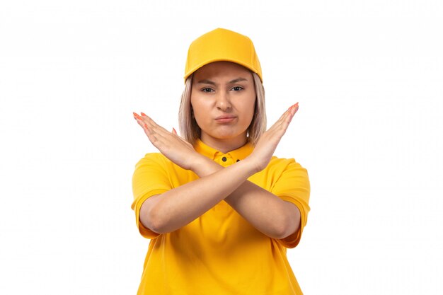 A front view female courier in yellow shirt yellow cap and black jeans posing showing bann sign on white