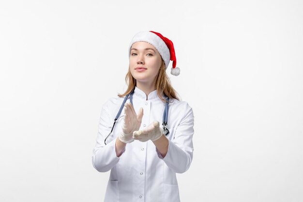 Front view of female doctor clapping on white wall