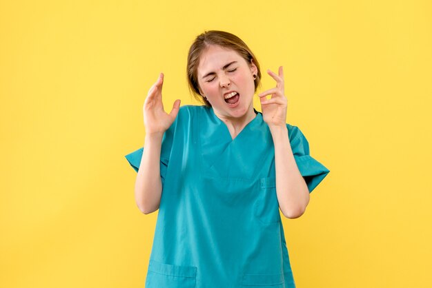 Front view female doctor displeased on a yellow background health emotion hospital medic