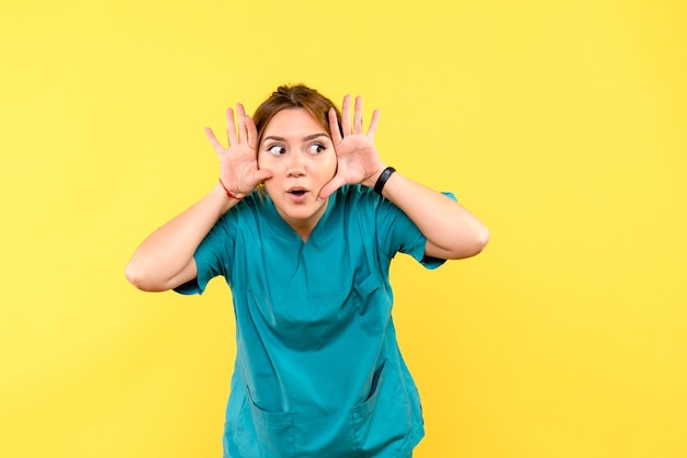 Front view female doctor feeling curious on yellow space