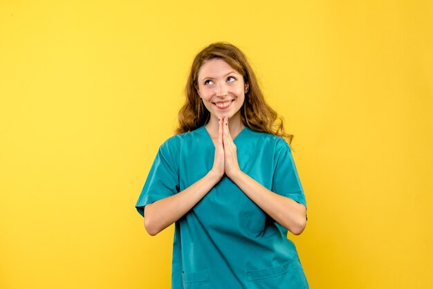 Front view female doctor happily dreaming on yellow space