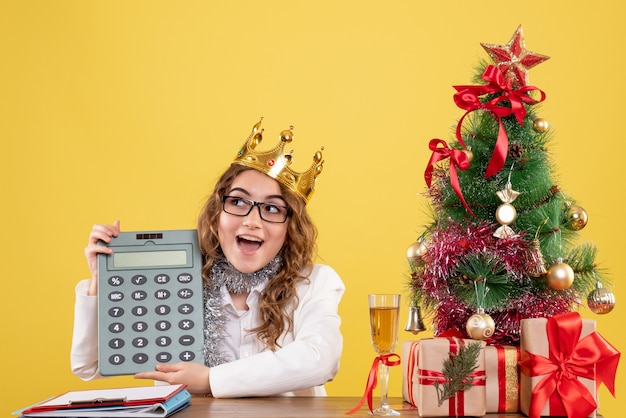 Free photo front view female doctor holding calculator with crown