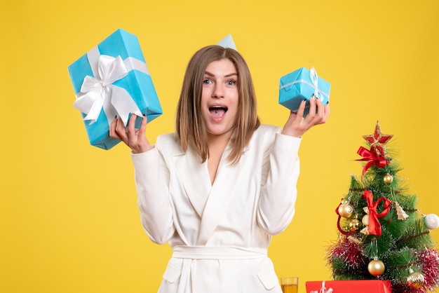 Front view female doctor holding christmas presents