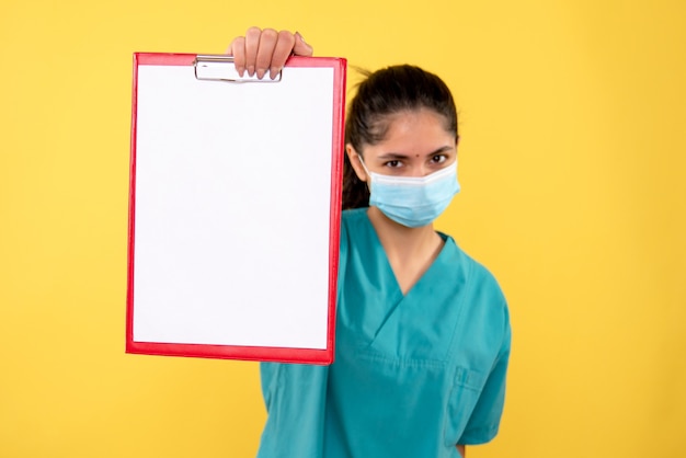 Free photo front view female doctor holding clipboard in her hand standing