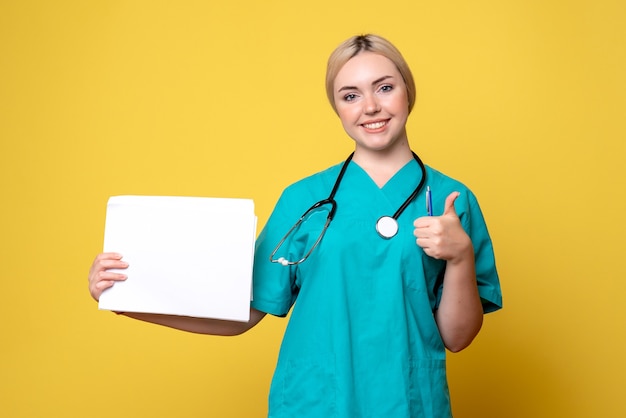 Front view female doctor holding different papers, virus pandemic health medic covid-19 hospital nurse