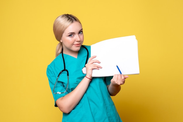 Front view female doctor holding different papers, virus pandemic medic covid-19 hospital nurse