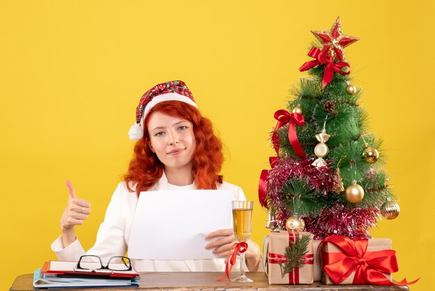 Front view female doctor holding documents behind table with presents