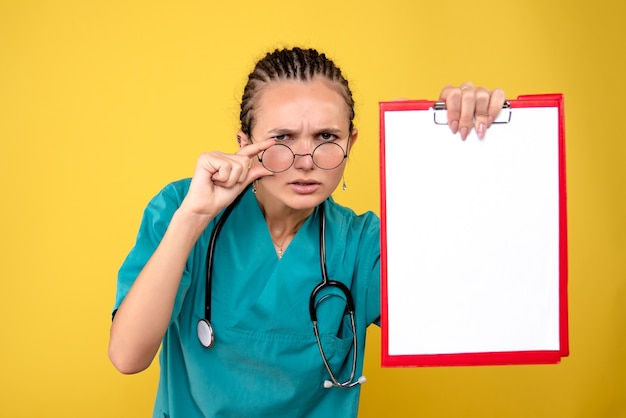 Free photo front view female doctor holding empty medical clipboard, color hospital emotion covid-19 medic health