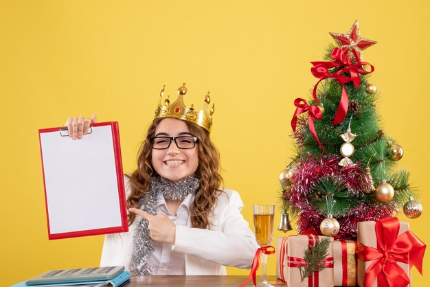 Front view female doctor holding file note with crown