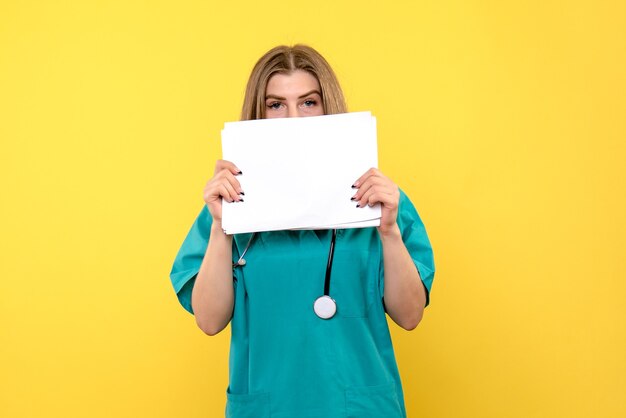 Front view female doctor holding files on yellow space