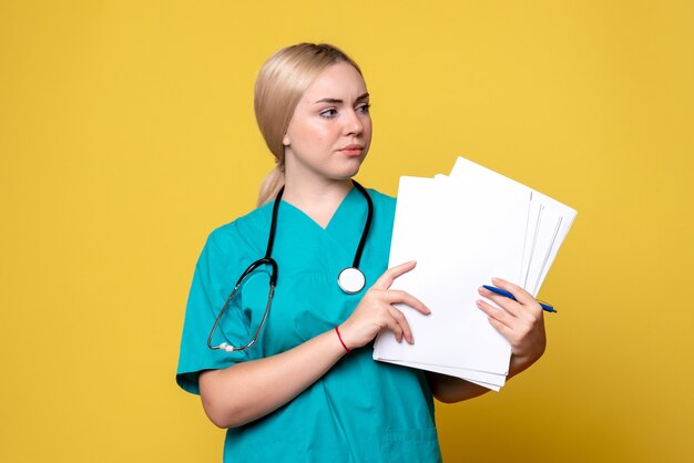 Front view female doctor holding papers, coronavirus health medic virus covid nurse hospital