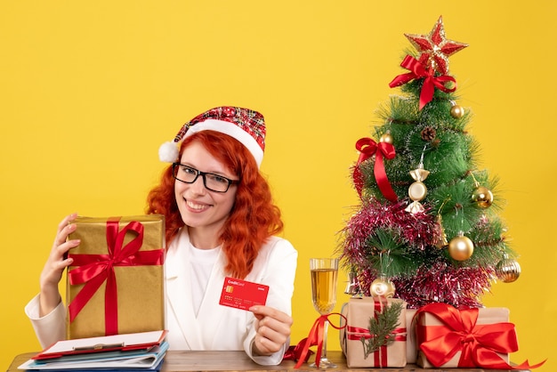 Front view female doctor holding present and bank card