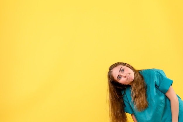 Front view female doctor making funny face on yellow background health medic hospital emotion