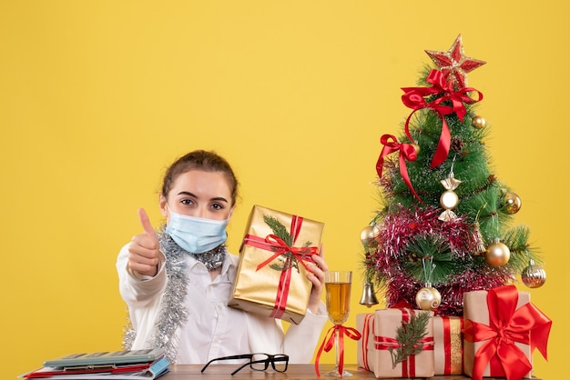 Front view female doctor in mask holding present