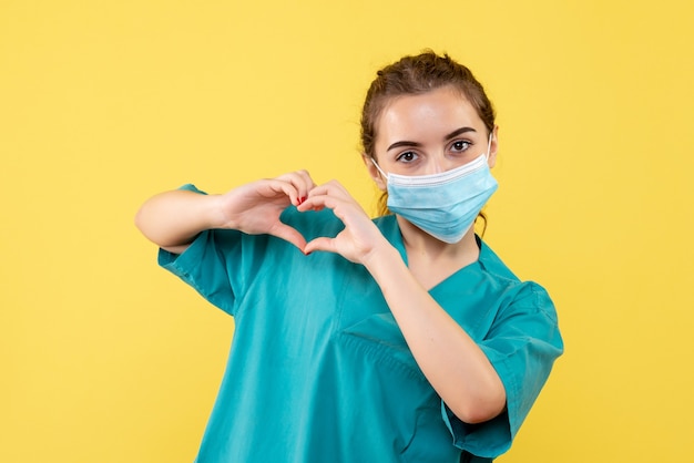 Front view female doctor in medical shirt and sterile mask, pandemic health uniform covid-19 virus