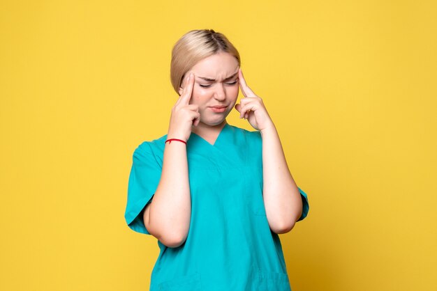 Front view female doctor in medical shirt suffering from headache, emotion pandemic nurse covid-19 medic