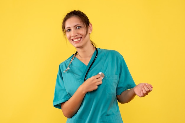 Free photo front view female doctor in medical shirt on the yellow background