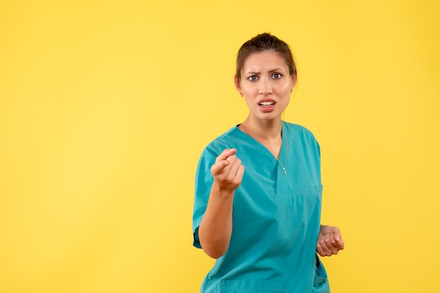 Free photo front view female doctor in medical shirt on yellow background