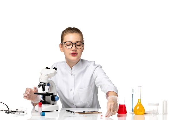 Free Photo front view female doctor in medical suit with gloves in working process on a white space