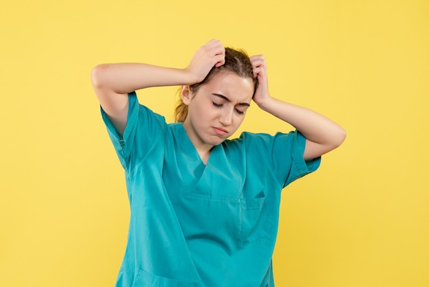 Free photo front view of female doctor in medical suit on yellow wall