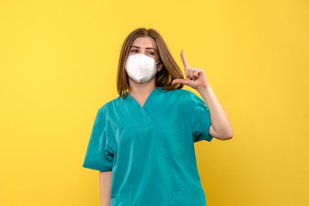 Free Photo front view female doctor posing on a yellow space