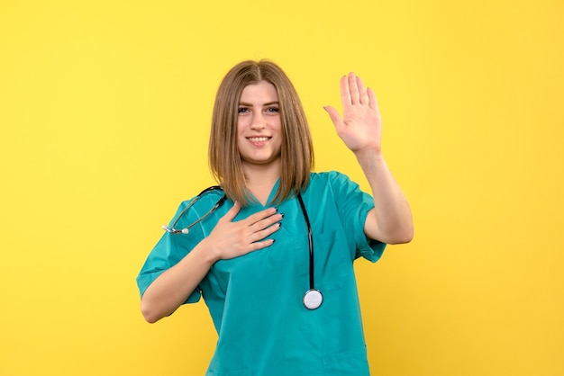 Front view female doctor posing on the yellow space