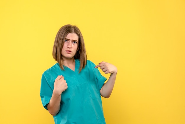 Front view female doctor posing on yellow space